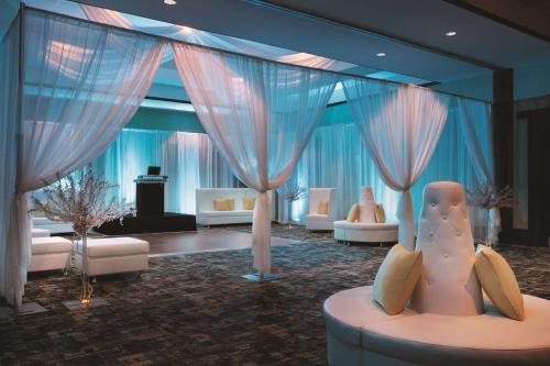 a living room with white furniture and curtains at Embassy Suites by Hilton Orlando Lake Buena Vista South in Kissimmee