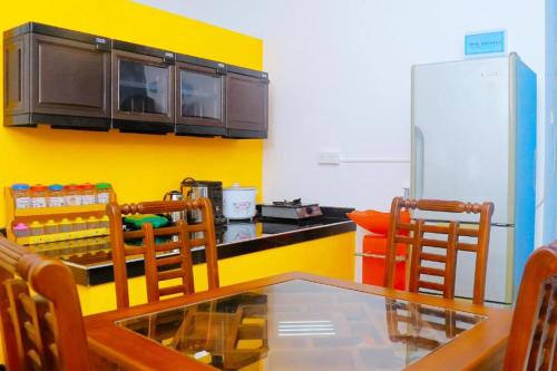 una cocina con mesa de comedor y refrigerador en villa surendra, en Weligama