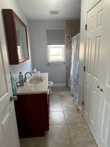 a bathroom with a sink and a toilet at NYC Adjacent Comfy 9 Guest Home in Passaic