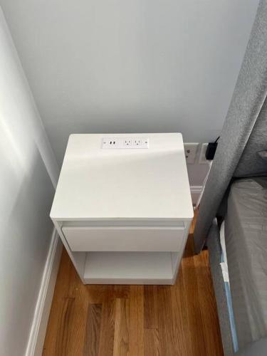 a white printer sitting in a corner of a room at NYC Adjacent Comfy 9 Guest Home in Passaic