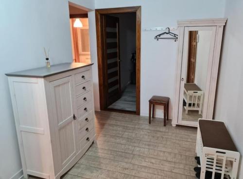 a kitchen with a white cabinet and a mirror at Anna's in Sibiu