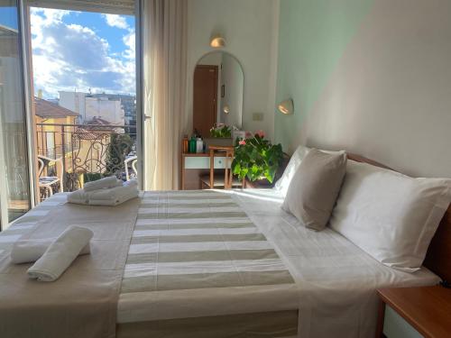 duże łóżko w pokoju z dużym oknem w obiekcie Hotel Villa Caterina w Rimini