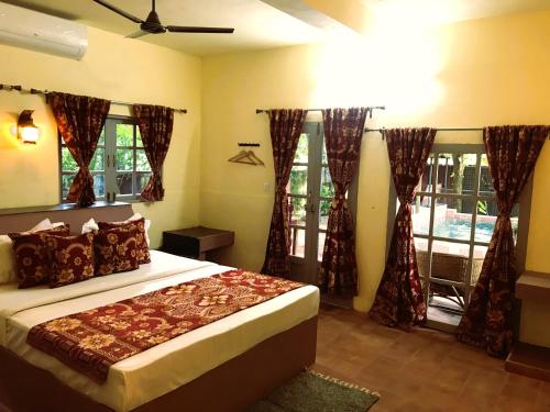 a bedroom with a bed in a room with windows at Marari Dreamz Homestay in Mararikulam