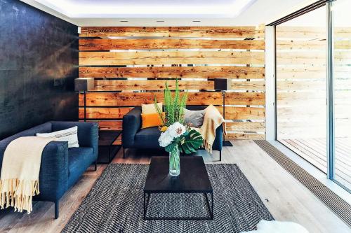 a living room with a blue couch and a wooden wall at Au Club Alpin in Champex