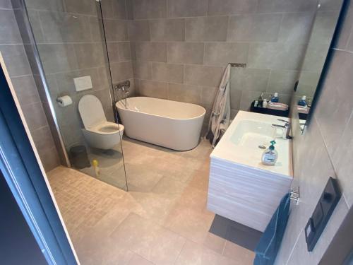 a bathroom with a shower and a toilet and a sink at Moderne hytte i Svandalen, Sauda - nær skisenter og natur in Sauda