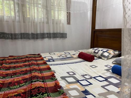 un letto con una trapunta in una camera da letto di Kumara villa a Hikkaduwa