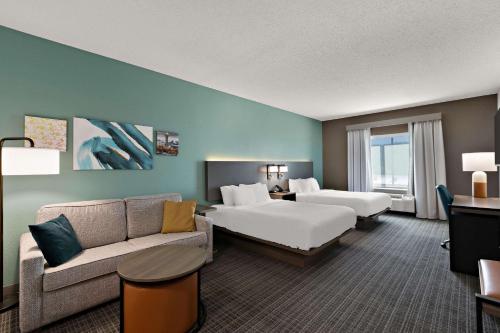 een hotelkamer met 2 bedden en een bank bij Comfort Inn Powell - Knoxville North in Knoxville