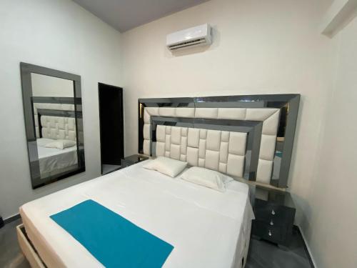 a bedroom with a large bed and a mirror at Hotel Hostal Caps Cartagena in Cartagena de Indias