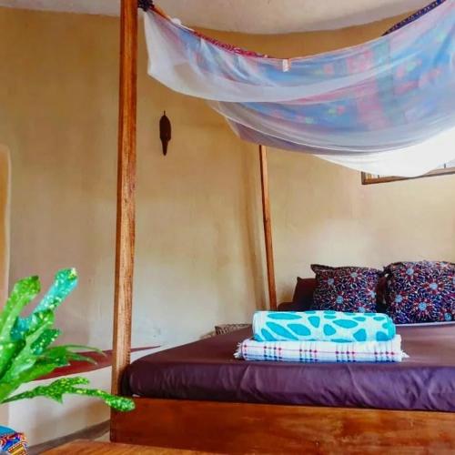 a bedroom with a bed with a canopy at Butterfly Space- A Non-Profit Eco-Lodge in Nkhata Bay