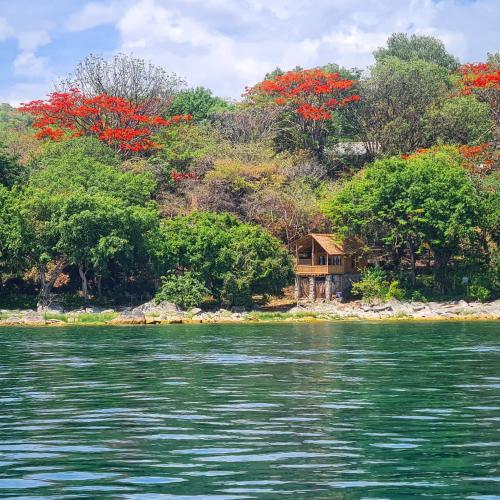 a house on the shore of a body of water at Butterfly Space- A Non-Profit Eco-Lodge in Nkhata Bay