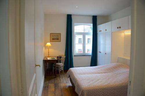 1 dormitorio con cama, escritorio y ventana en Les Hys de Verdenne, en Marche-en-Famenne