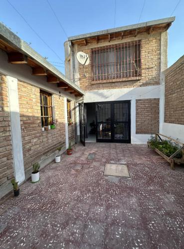 un edificio de ladrillo con una puerta grande y un patio en Habitacion DOBLE en casa compartida en Godoy Cruz