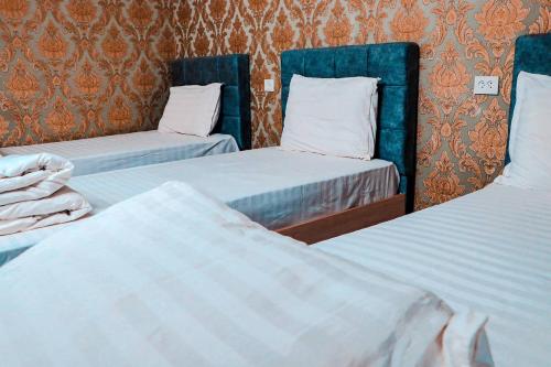 Fotih Hotel في Sergeli: سريرين في غرفة فندق مع
