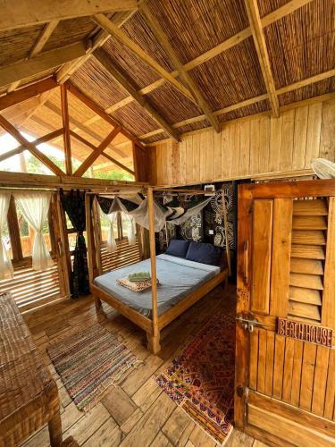 a bedroom with a bed in a wooden house at Butterfly Space- A Non-Profit Eco-Lodge in Nkhata Bay