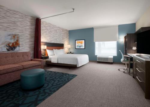 Habitación de hotel con cama y sofá en Home2 Suites by Hilton Orlando South Davenport en Davenport