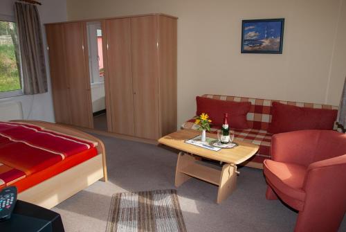 a living room with a couch and a table at Doppelzimmer-mit-Gemeinschaftsbad-fuer-2-Personen-auf-Ruegen-H4Zi1 in Rappin