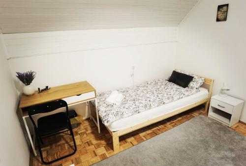 Habitación pequeña con cama y escritorio. en Privatni Smještaj Harmony, en Osijek