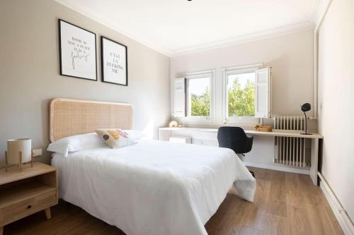 um quarto branco com uma cama branca e 2 janelas em Idyllic apartment in Vic center em Vic