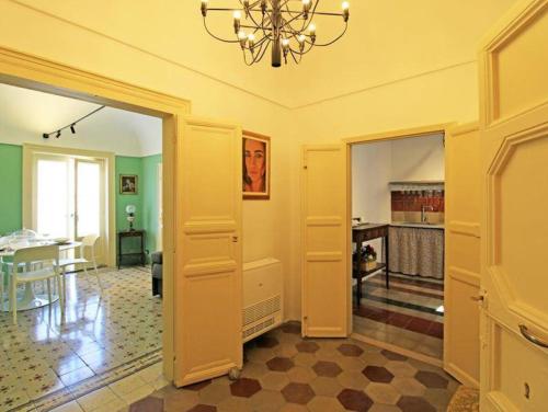 a living room with a chandelier and a dining room at Casa Tiffany in Modica