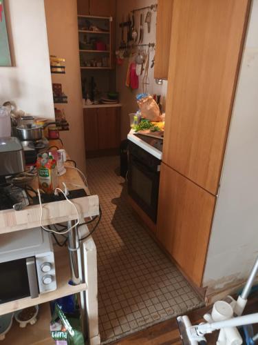 a kitchen with a stove and a refrigerator at mini loft souplex canal st martin in Paris