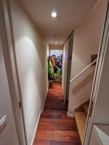 a long hallway with wooden floors and stairs at mini loft souplex canal st martin in Paris