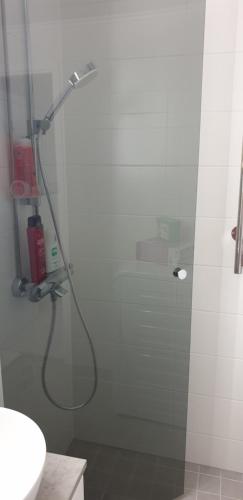 a shower in a bathroom with a glass door at City center apartment in Pieksamaki
