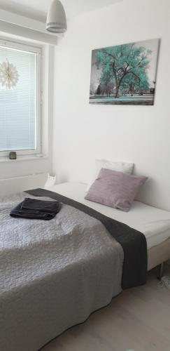um quarto com uma cama com uma fotografia na parede em City center apartment em Pieksamaki