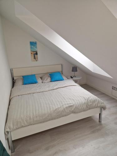 a white bedroom with a bed with blue pillows at sandra1 in Jantar