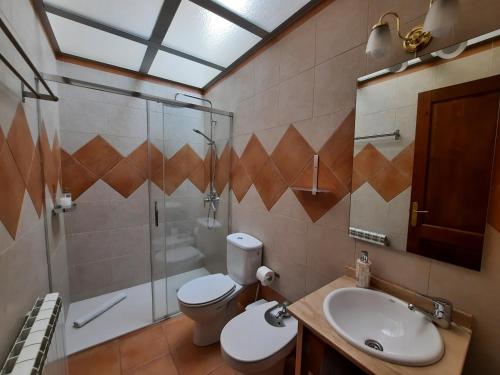 a bathroom with a toilet and a shower and a sink at Casa Rural Rebost in Sant Llorenç de Morunys
