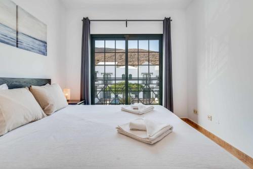 - une chambre avec un lit blanc et 2 serviettes dans l'établissement Residencial Las Candelarias 30, à Agaete