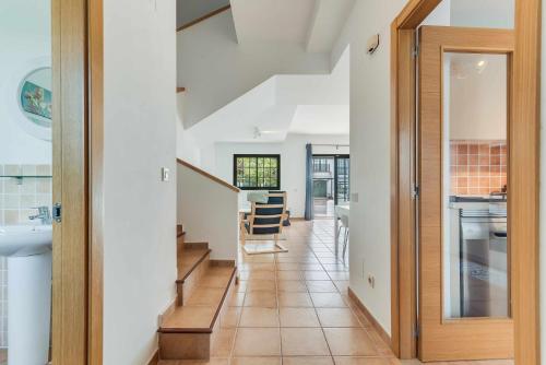 um corredor com uma porta que dá acesso a uma cozinha com uma escada em Residencial Las Candelarias 35 em Agaete