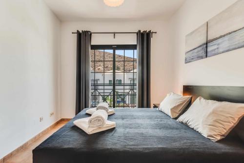 - une chambre avec un grand lit et des serviettes dans l'établissement Residencial Las Candelarias 35, à Agaete