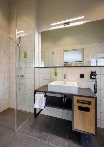 a bathroom with a sink and a shower at JUFA Hotel Bregenz in Bregenz