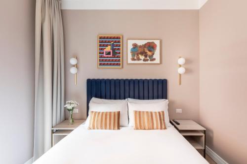 una camera da letto con letto con testiera blu e 2 cuscini di Numa Rome Linea a Roma
