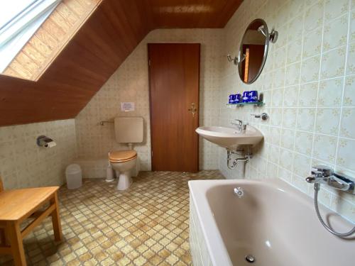 een badkamer met een bad, een toilet en een wastafel bij Ferienhaus Küste in Otterndorf