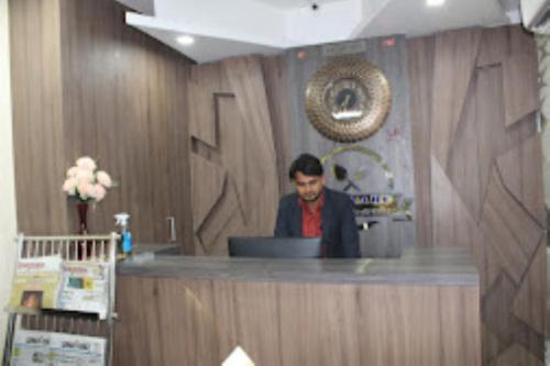 a man standing at a counter in a room at HOTEL Z SQUARE , Aurangabad in Aurangābād