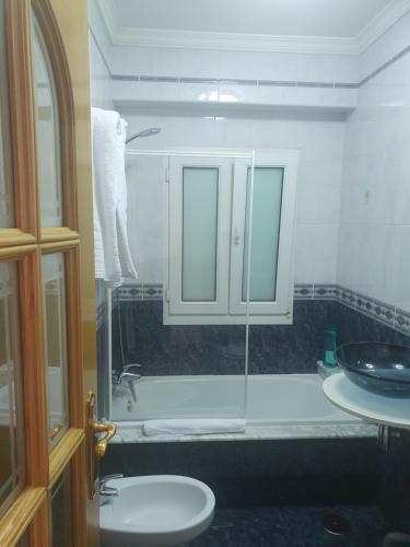 uma casa de banho com um lavatório e uma cabina de duche em vidro. em Chocolate Alojamiento em Muxía