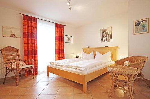 a bedroom with a bed and two chairs and a table at Am Stadtwald in Kühlungsborn
