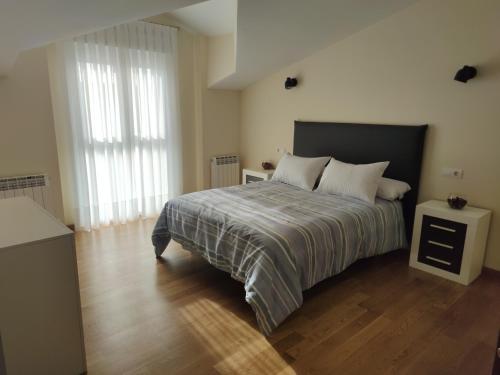 um quarto com uma cama grande e piso em madeira em Chalet con amplio jardín em Casalarreina