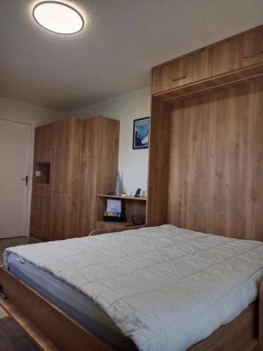 une chambre avec un grand lit avec une tête de lit en bois dans l'établissement Appartement - Combloux, à Combloux