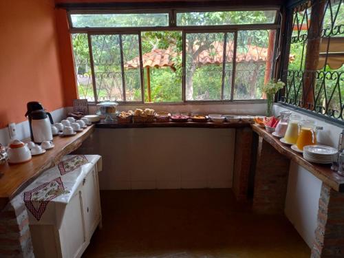 uma cozinha com uma mesa com comida em Cipó Hostel em Serra do Cipó