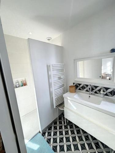 ein weißes Badezimmer mit einem Waschbecken und einem Spiegel in der Unterkunft L'écrin Lauragais - Grande maison, 3 chambres 3sdb in Villefranche-de-Lauragais