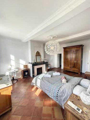 un dormitorio con una cama con un animal de peluche en L'écrin Lauragais - Grande maison, 3 chambres 3sdb en Villefranche-de-Lauragais
