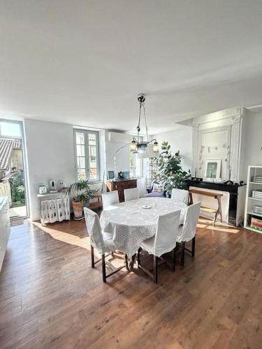 une salle à manger avec une table et des chaises blanches dans l'établissement L'écrin Lauragais - Grande maison, 3 chambres 3sdb, à Villefranche-de-Lauragais