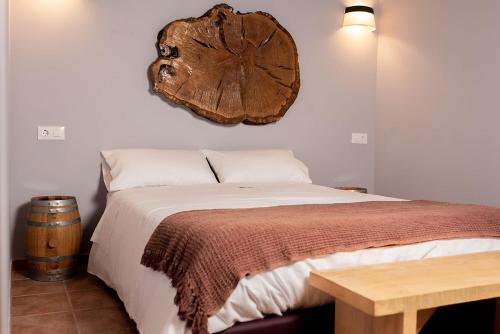 Schlafzimmer mit einem Bett und einer hölzernen Uhr an der Wand in der Unterkunft Pallozas Turísticas Ridicodias - A Vieira in Laza