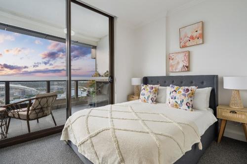 a bedroom with a large bed and a balcony at The Sky Garden in Sydney