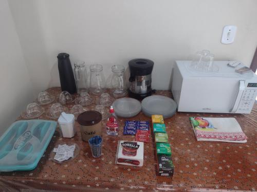 a counter top with wine glasses and a microwave at Pousada Mar e Sol in Saquarema
