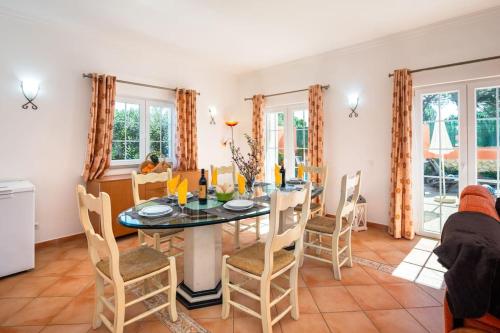 a kitchen and dining room with a table and chairs at Private Villa Ribeiro I Heated Pool, 4 Bed, BBQ, AC, WIFI, BEACH in Albufeira
