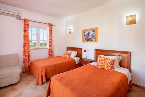 a hotel room with two beds and a window at Private Villa Ribeiro I Heated Pool, 4 Bed, BBQ, AC, WIFI, BEACH in Albufeira