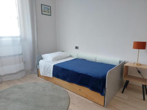 ein Schlafzimmer mit einem Bett mit einer blauen Decke und einem Tisch in der Unterkunft Il Melograno in Toscana in Castelfranco di Sopra